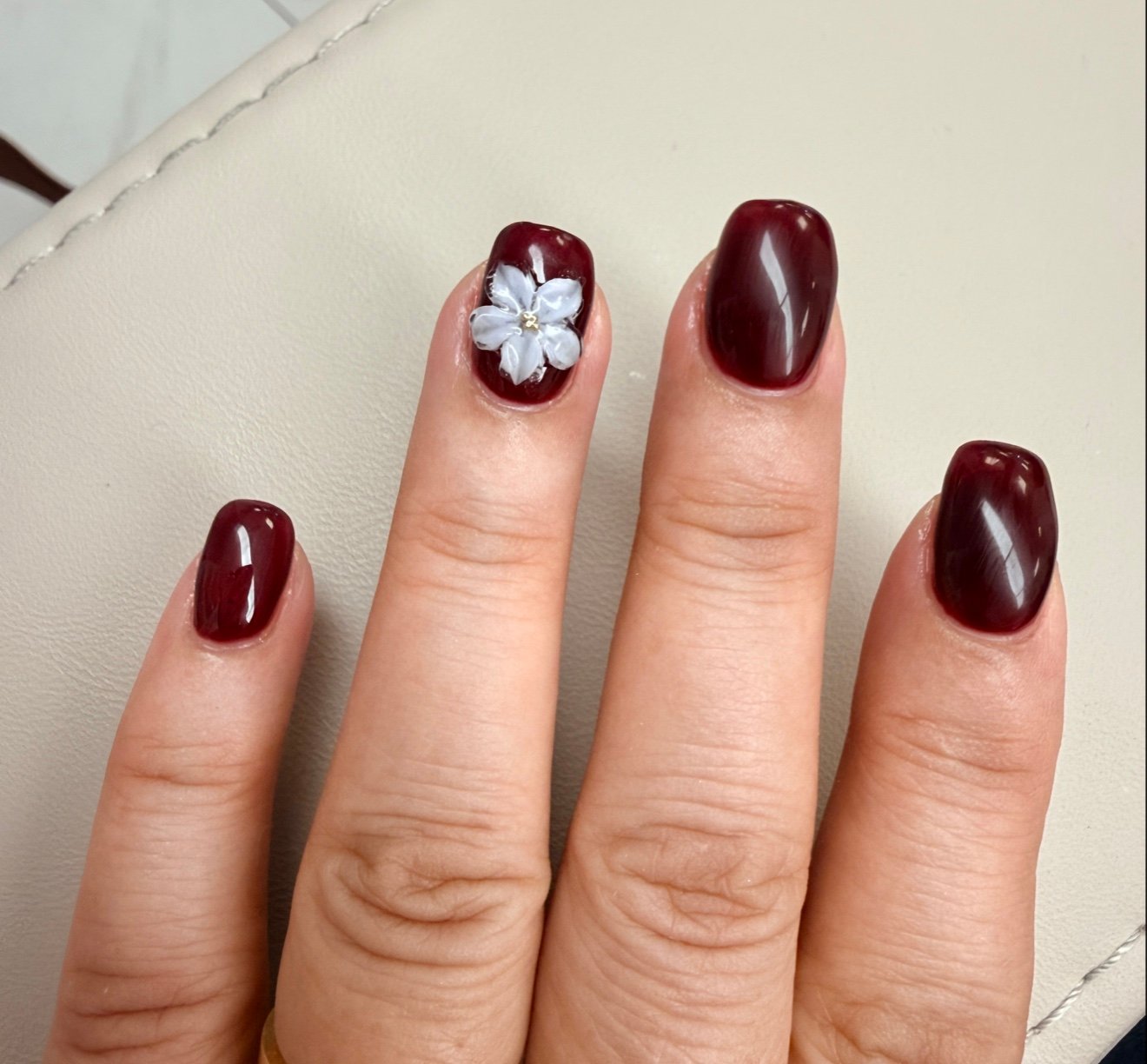 Burgundy gel manicure with hand-painted floral nail art Flushing NY