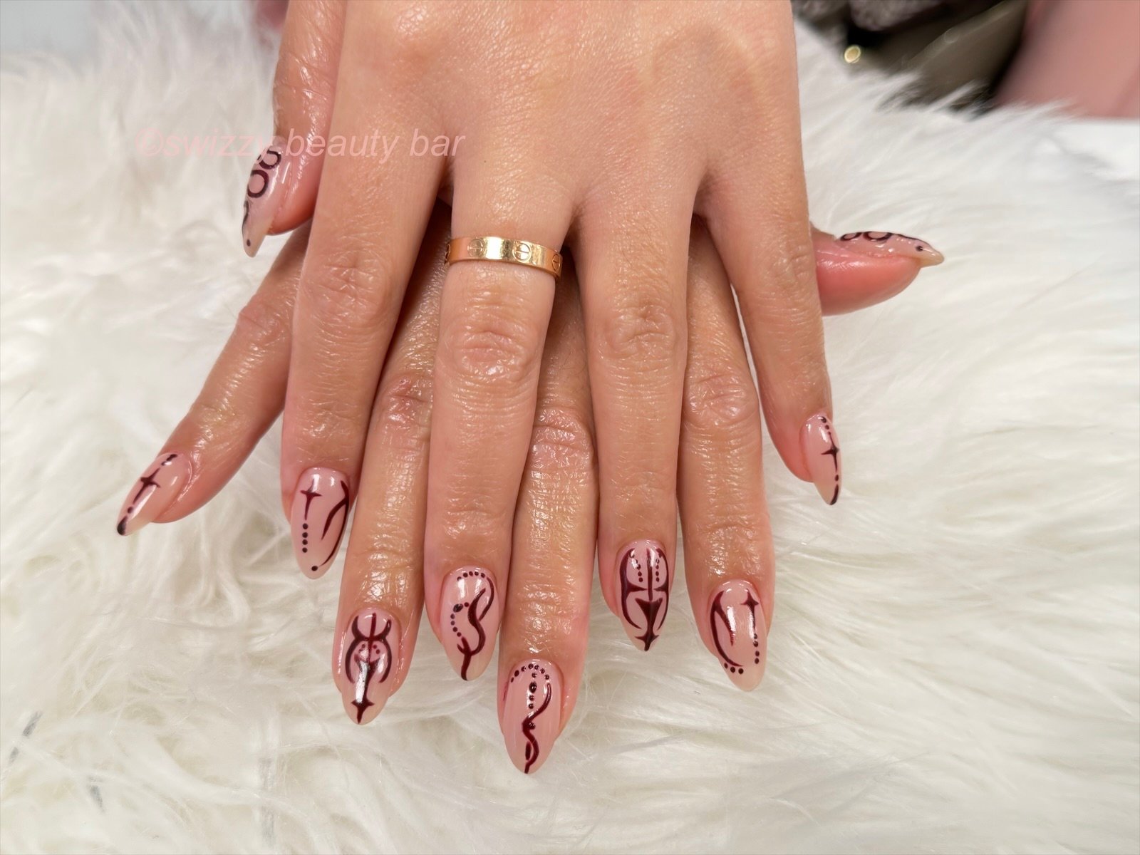 Nude gel nails with hand-painted burgundy abstract line art at Swizzy Beauty Bar, Flushing NY