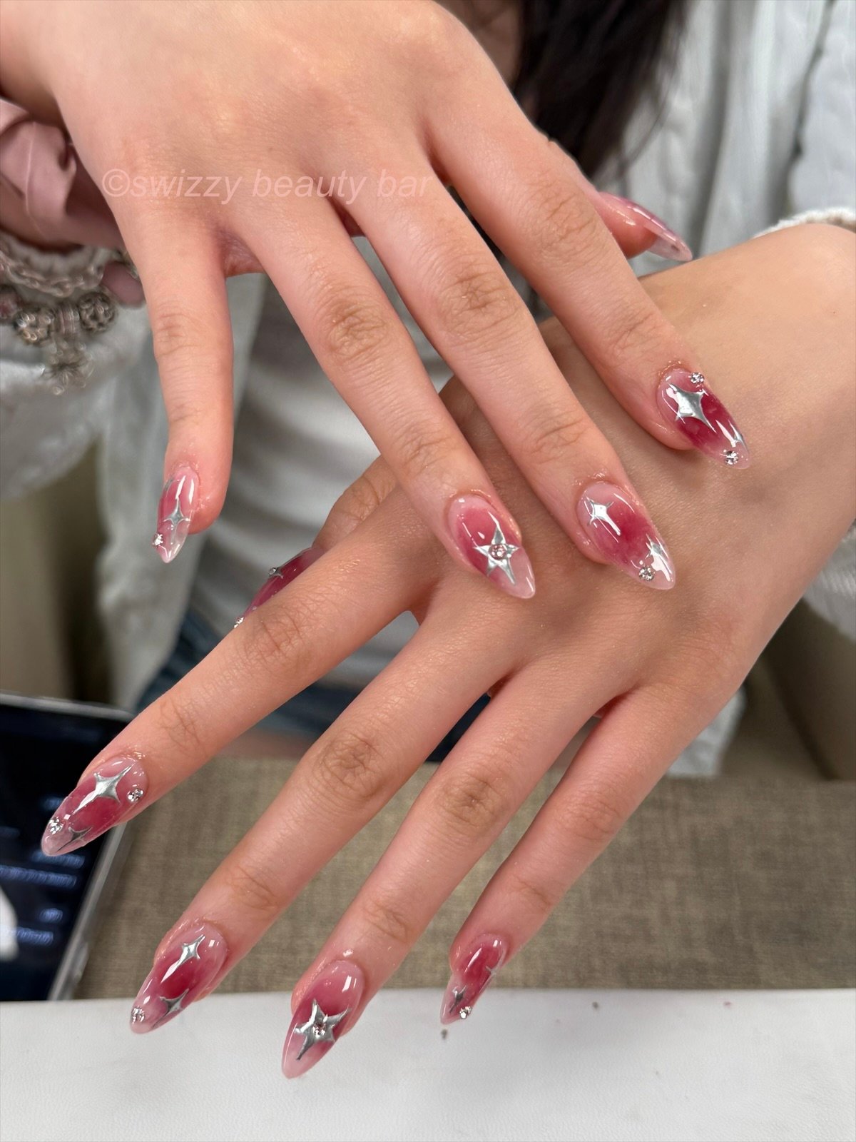 Rose ombre almond gel nails with silver 3D stars and rhinestones at Swizzy Beauty Bar, Flushing NY